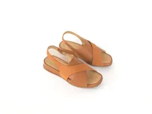 Sandalias Tami de cuero color caramelo, con tiras cruzadas en el empeine, talón con elástico y plataforma baja.