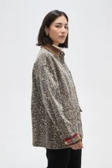 Campera de jean con estampado animal print, cuello de pana en color marrón, cierre frontal con botones metálicos, bolsillos frontales con solapa y puños con detalle de tela escocesa en tonos rojos y azules.