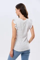 Musculosa blanca con estampado floreado sutil y volados en los hombros, de corte recto.