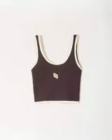 Top sin mangas color marrón oscuro con ribetes color beige, corte crop y logo bordado en el centro del pecho.