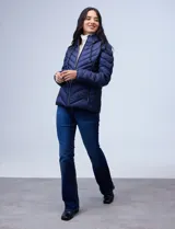 Campera de abrigo verde esmeralda, marca Michael Kors. Diseño acolchado con cierre metálico central, capucha no desmontable con cordón de ajuste y bolsillos verticales delanteros. Incluye bolsa autoportante.