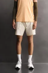 Shorts deportivos de entrenamiento Zara Athleticz, color beige, confeccionados en tejido técnico ligero y elástico con forro interior. Presentan cintura elástica ajustable, bolsillos frontales, bolsillo trasero de seguridad con cierre, aberturas laterales en el bajo y detalle de logo estampado en la pierna.