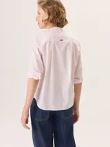 Camisa de corte recto y manga larga, con diseño a rayas verticales y detalle de volados en el frente. Confeccionada en algodón.
