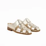 Zueco de cuero metalizado dorado, diseño artesanal con capellada en tiritas cruzadas estilo romano y talón descubierto con suela plana y pequeño taco de madera.