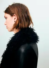Abrigo largo de efecto piel con detalles de pelo sintético en cuello, puños y ruedo. Presenta diseño recto, cuello de pico, cierre frontal con botones y bolsillos laterales.