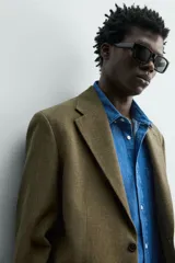 Blazer regular fit de Zara Origins, confeccionada en tejido de lana y algodón color verde militar. Presenta cuello con solapas de muesca, cierre frontal de un botón, bolsillos de solapa en la cadera y bolsillo de vivo en el pecho.