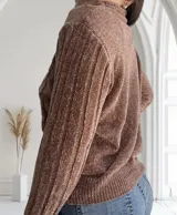 Sweater color camel de punto con cuello alto y mangas largas con diseño de trenzas.