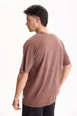 Remera oversize de manga corta raglán, color negro con efecto lavado acid wash, corte semi boxy y detalle de etiqueta lateral en el ruedo.
