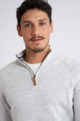 Buzo gris jaspeado de tejido de punto, con medio cierre frontal, cuello alto, manga larga y logo en goma. Corte regular.