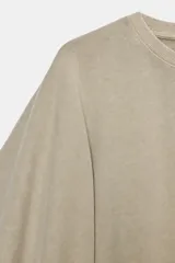 Camiseta blanca de manga corta con corte oversize y cuello redondo. El diseño presenta mangas amplias tipo capa que caen desde el hombro.