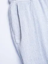 Pantalón celeste a rayas verticales blancas, de corte recto, con cintura elástica y cordón ajustable.