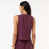 Top sin mangas de color bordó, confeccionado en tejido con textura fruncida. Presenta cuello redondo con detalle de volado y ruedo con terminación similar.