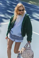 Chaqueta de polar suave y esponjosa color verde oscuro, con cierre a presión frontal, bolsillos con cremallera y parches de nailon. Tiene una silueta ligeramente oversize y llega justo por debajo de la cintura.