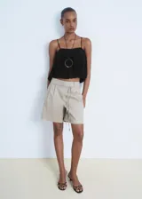 Top negro sin mangas, estilo crop, con tirantes finos ajustables y diseño fruncido que le da un efecto globo.