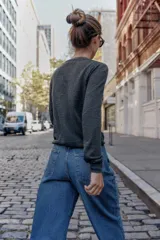 Chaqueta de punto con cuello en pico y manga larga. Presenta un diseño de estampado de rombos en tonos gris, beige y blanco en la parte frontal y cierre frontal con botones.