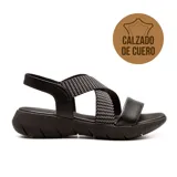 Sandalias bajas de cuero negro, con tiras cruzadas en el empeine y ajuste con hebilla en el tobillo. Suela con plataforma baja y plantilla acolchada para mayor confort.