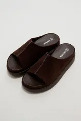 Sandalias de gamuza marrón, diseño abierto con tira ancha en el empeine y suela plana de goma.