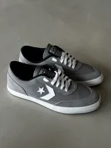 Championes urbanos de caña baja Converse Net Star, color gris con detalles en blanco y negro. Capellada de lona de algodón combinada con suede, logo Star Chevron aplicado y suela de caucho.