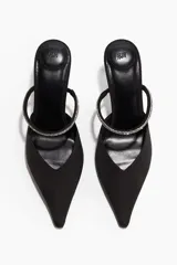 Sandalias tipo mule de tela negra con punta fina y taco fino forrado. Presenta una tira fina en el empeine decorada con strass y elástico lateral para mayor ajuste.