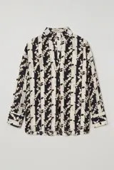 Blusa de manga larga con estampado en tonos marrones y blancos, cuello camisero y escote en V profundo.