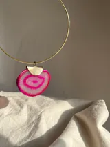 Gargantilla dorada con dije de ágata rosa y dije metálico plateado en forma de media luna.