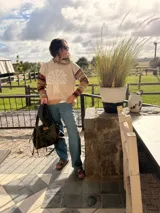 Sweater canguro de lana color beige con capucha, bordado a mano con un árbol en el frente y mangas a rayas en tonos tierra.