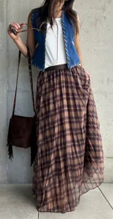 Falda larga plisada con estampado de cuadros en tonos camel y marrón, confeccionada en tejido liviano con cintura elástica.
