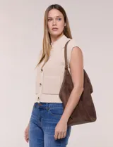 Cartera tipo hobo de gran capacidad confeccionada en símil gamuza color marrón, con diseño relajado, base sólida reforzada y ribete de cuerina a juego en los bordes. Cuenta con una sola asa de hombro y un compartimento interior independiente.