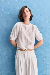 Blusa de manga corta color rosado con estampa orgánica de inspiración floral, cuello redondo y ajuste mediante lazo en el ruedo.