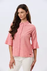 Camisa de lino celeste con cuello clásico, cierre frontal con botones y mangas tres cuartos terminadas en volados.