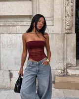 Top strapless de diseño entallado, confeccionado con superposición de tela lisa y malla fruncida translúcida en tono bordó, con dobladillo inferior en punta.