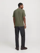 Polo de manga corta confeccionado en tejido de punto estructurado con textura sutil. Presenta cuello clásico, cierre frontal con botones y terminaciones acanaladas en mangas y ruedo.