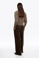 Pantalón de corte recto y holgado confeccionado en pana de algodón color marrón oscuro. Presenta tiro medio, cintura elástica y bolsillos laterales.