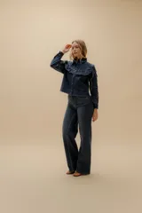 Camisa/chaqueta de denim azul con volados en el frente y en las mangas.