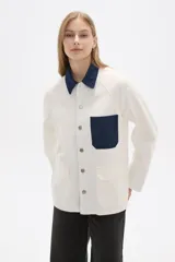 Chaqueta color crudo de algodón con cuello camisero y detalles en denim azul en cuello, bolsillo y puños.