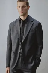 Blazer gris oscuro de corte regular fit con diseño de raya diplomática, confeccionado con mezcla de lana. Presenta solapas de muesca, cierre frontal de dos botones, bolsillos con solapa en la cadera y un bolsillo de vivo en el pecho.