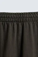 Pantalón cargo de corte relajado con efecto lavado, confeccionado en tejido de algodón. Presenta cintura elástica, bolsillos laterales de plastrón con solapa y bolsillos delanteros.