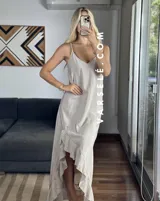 Vestido largo color marrón con breteles finos y volados asimétricos en el ruedo.