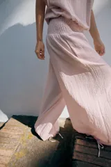 Pantalón baggy de tiro medio color rosado, con cintura elástica fruncida tipo nido de abeja y bajos ajustables con cordones.