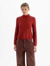 Sweater de cuello media polera y mangas largas, confeccionado en tejido liviano con trama en relieve tono sobre tono.