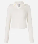 Blusa de manga larga confeccionada en tejido rib de algodón con cuello polo y escote en V. Presenta un diseño ajustado al cuerpo y acabado liso.