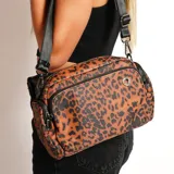 Cartera bandolera marrón con estampado animal print de leopardo en negro, con correa ancha ajustable de color negro.