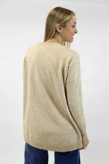 Buzo de punto negro, con cuello redondo, mangas largas y dobladillo asimétrico con aberturas laterales.