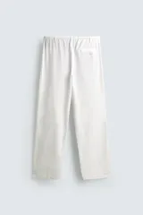 Pantalón de corte regular fit confeccionado en mezcla de algodón y lino. Presenta cintura elástica con cordón ajustable, cierre frontal con cremallera y botón, bolsillos laterales y bolsillo trasero de vivo con botón.