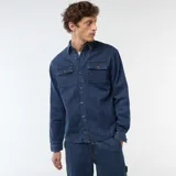 Camisa de denim azul con diseño de rayas verticales finas y blancas, manga larga con puños ajustables, cierre frontal de botones y dos bolsillos de parche con solapa en el pecho.