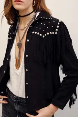 Camisa de gamuza negra con mangas largas, flecos y aplicación de tachas metálicas plateadas en la parte frontal y en los hombros.