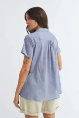 Camisa celeste de manga corta con cuello camisero y abotonadura frontal.