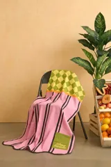 Pareo de algodón con diseño combinado que presenta un estampado de cuadros en tonos verde y amarillo en la parte superior, y un cuerpo rosado con rayas verticales negras y un bolsillo verde con inscripción bordada.