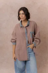 Camisa de denim color verde menta con calce relajado, cuello clásico, cierre frontal con broches metálicos, mangas largas y bolsillo aplicado en el pecho, con detalles en tono gris azulado a contraste en cuello, cartera, bolsillo y puños.