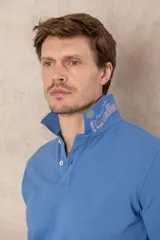 Chomba azul de piqué de algodón con cuello polo, tapeta de dos botones con diseño estampado en el interior y mangas cortas. Corte clásico.